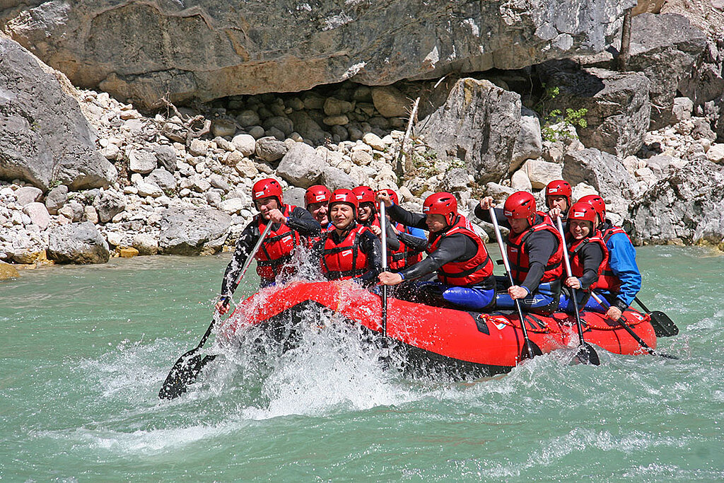 Eine Gruppe Wassersportler macht eine Wildwassertour auf einem Motor-Schlauchboot