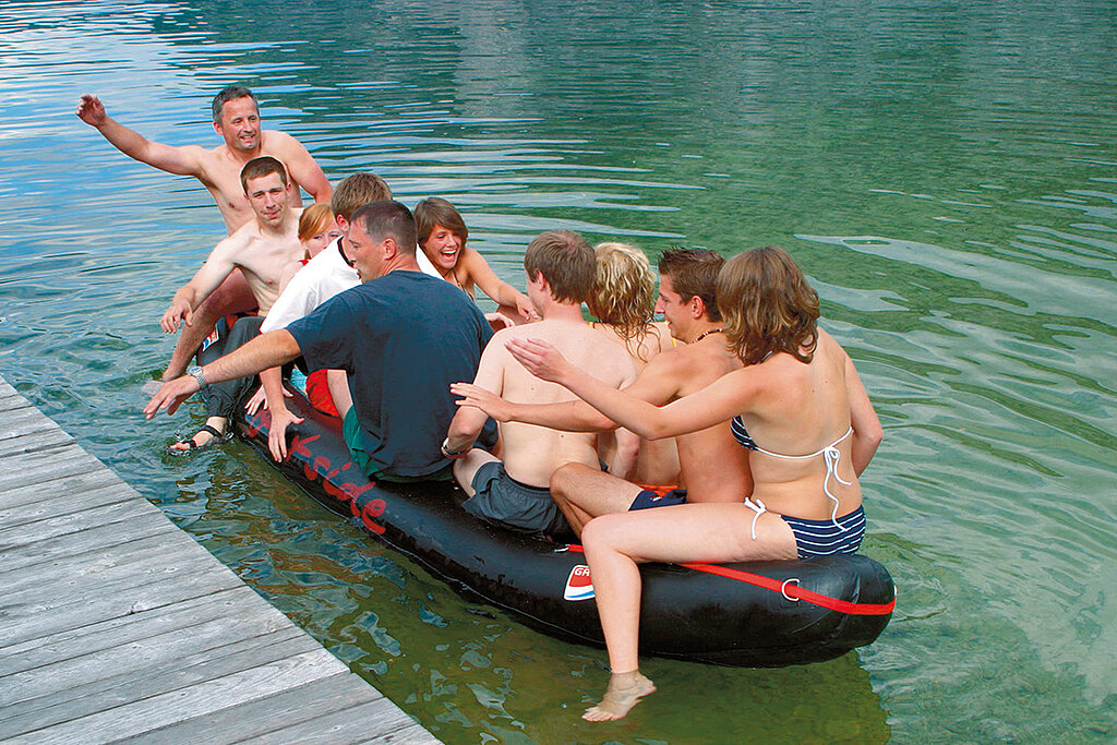 Eine Gruppe von Menschen macht eine spaßige Bootstour auf einem Schlauchboot mit Motor