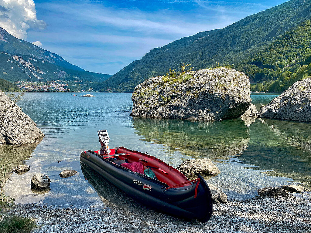 Robustes Schlauchboot mit Motor auf einem steinigen Untergrund